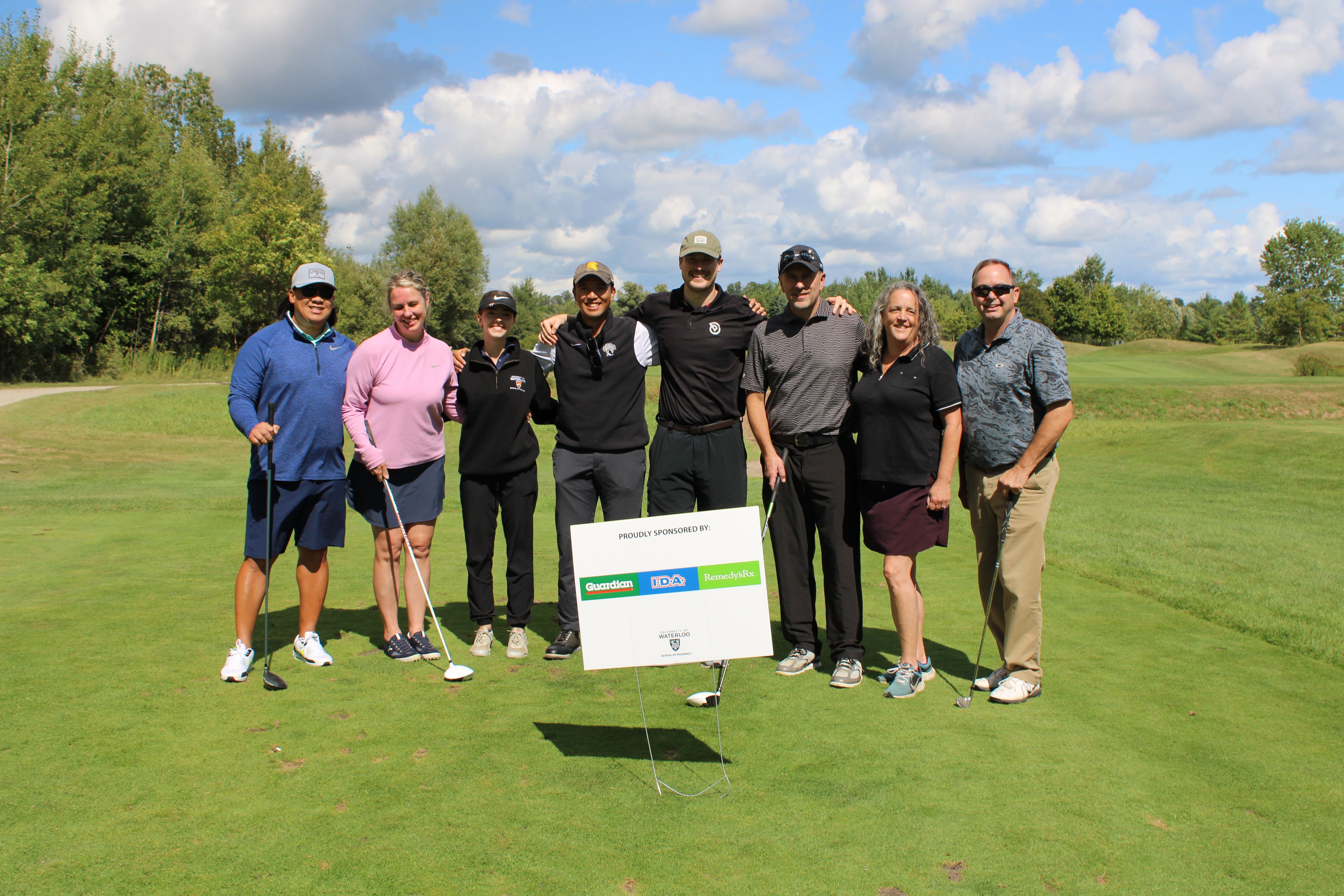 A group of people smiling on a golf course