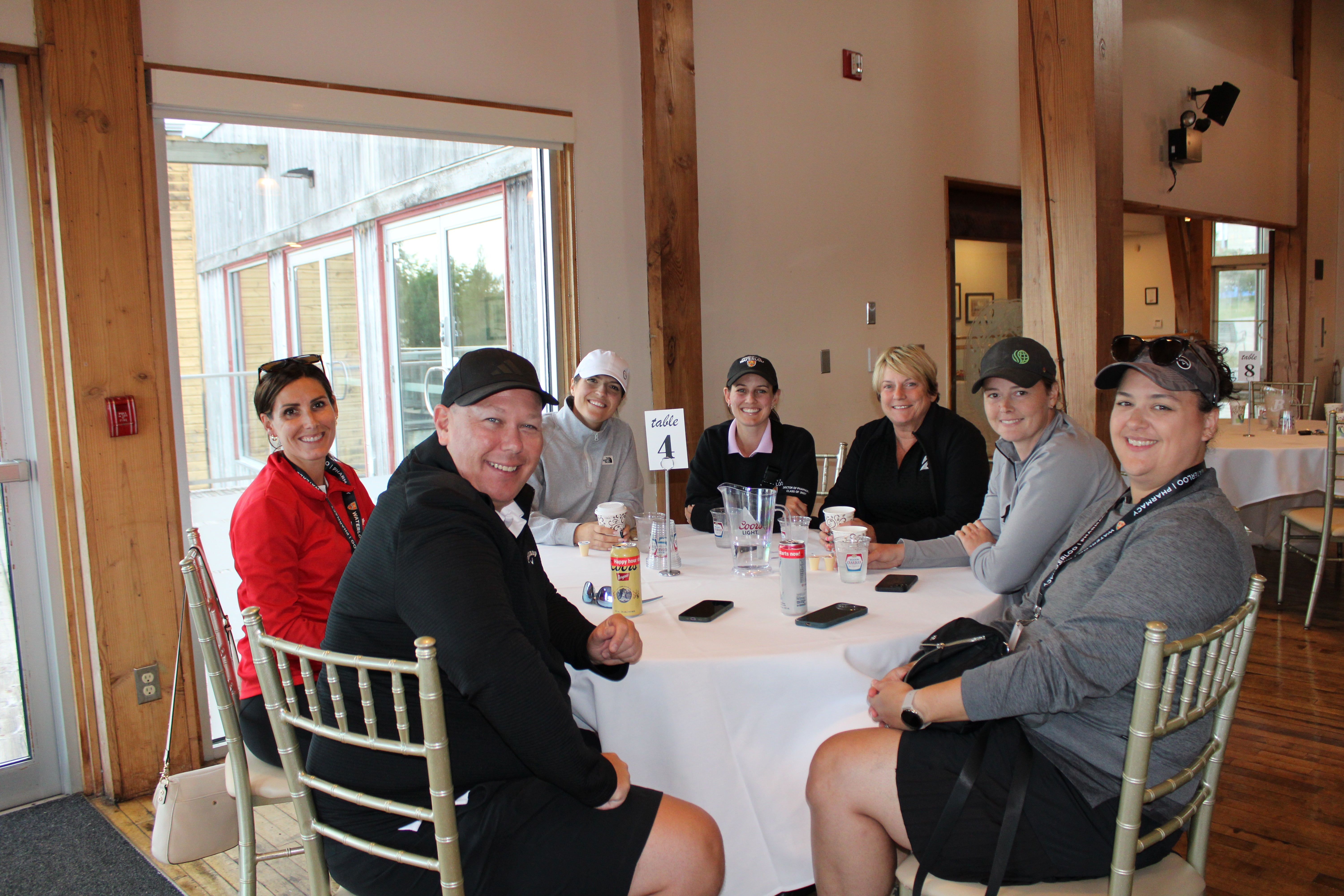 A group of people sitting around a table smiling