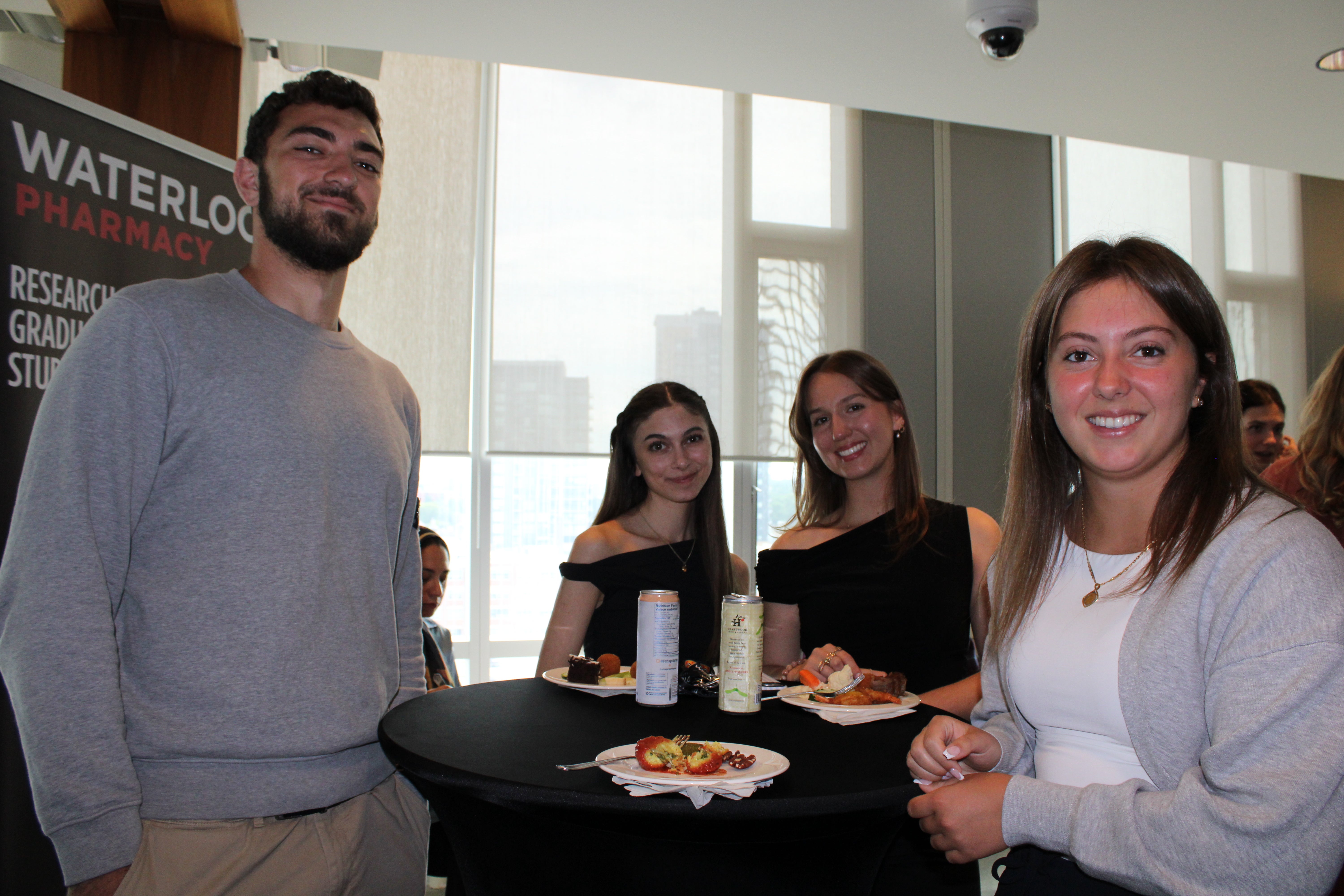 Students smiling around a cruiser table in a campus lounge