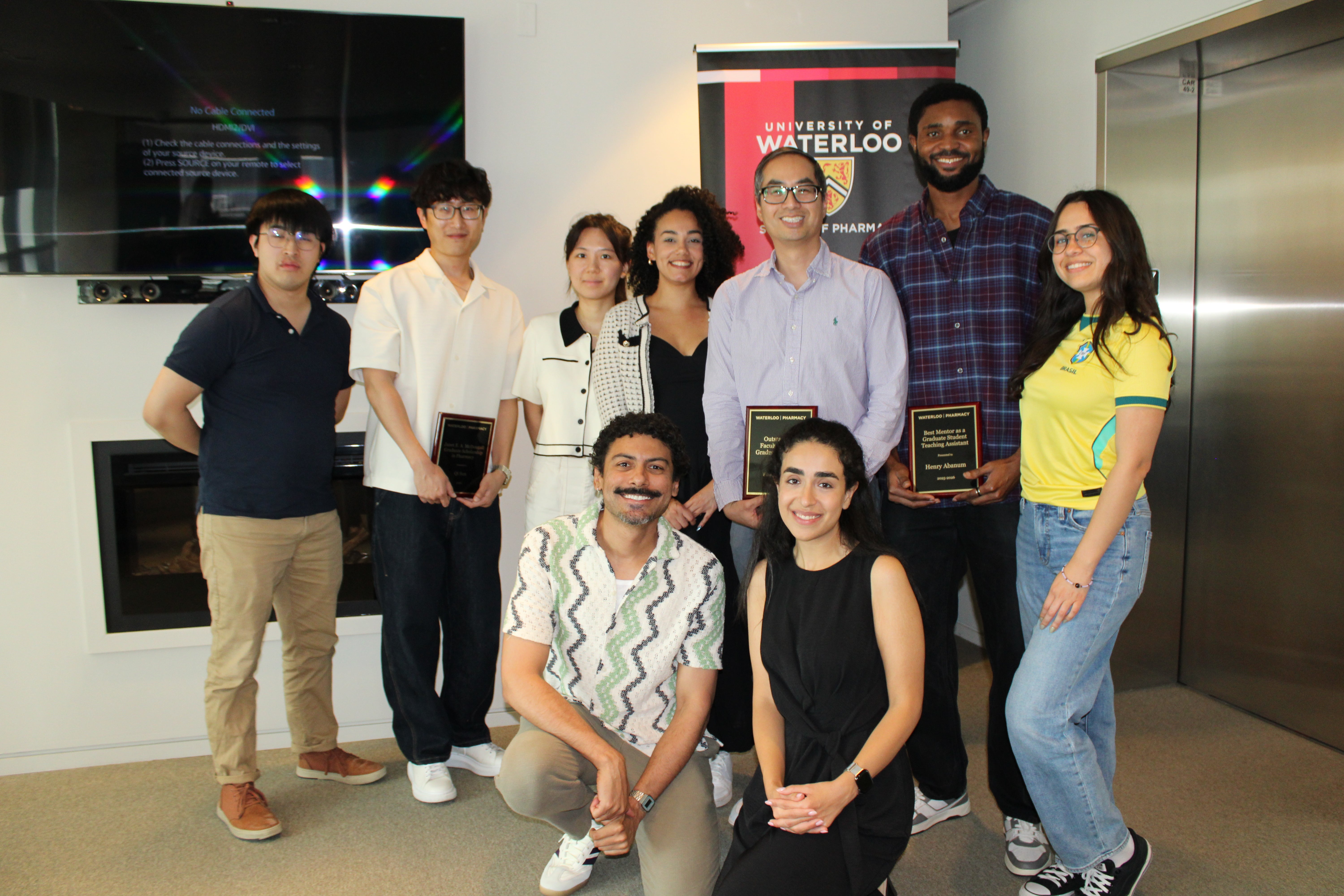 A group of people standing smiling holding an award