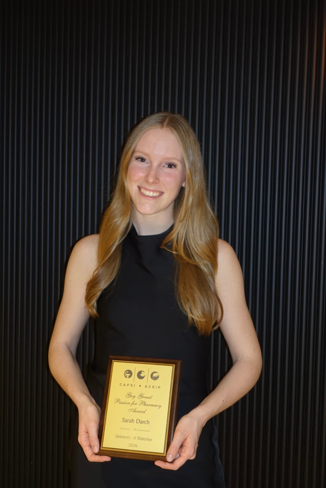 A student holding up an award