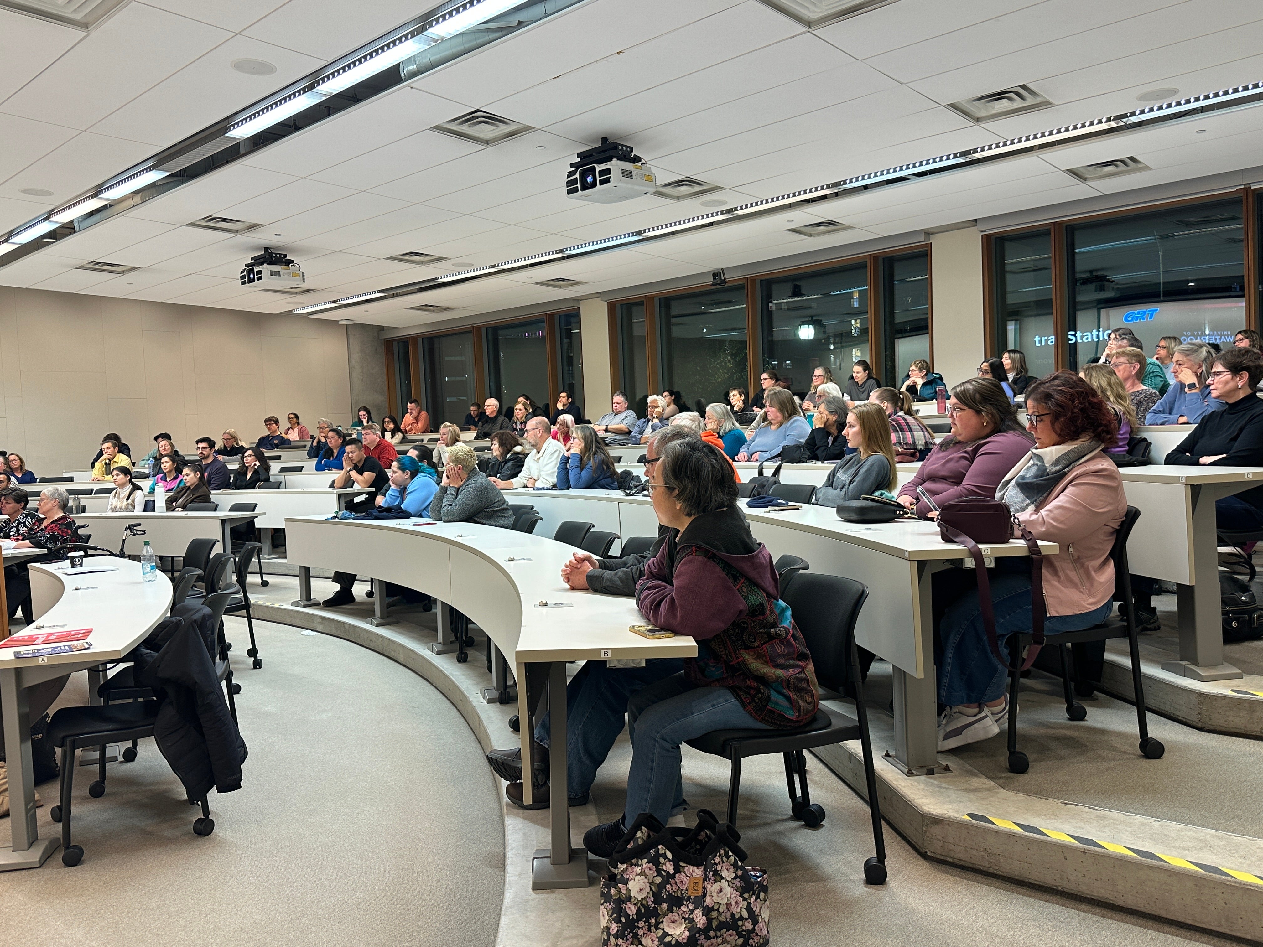 A classroom full of people listening to a presentation