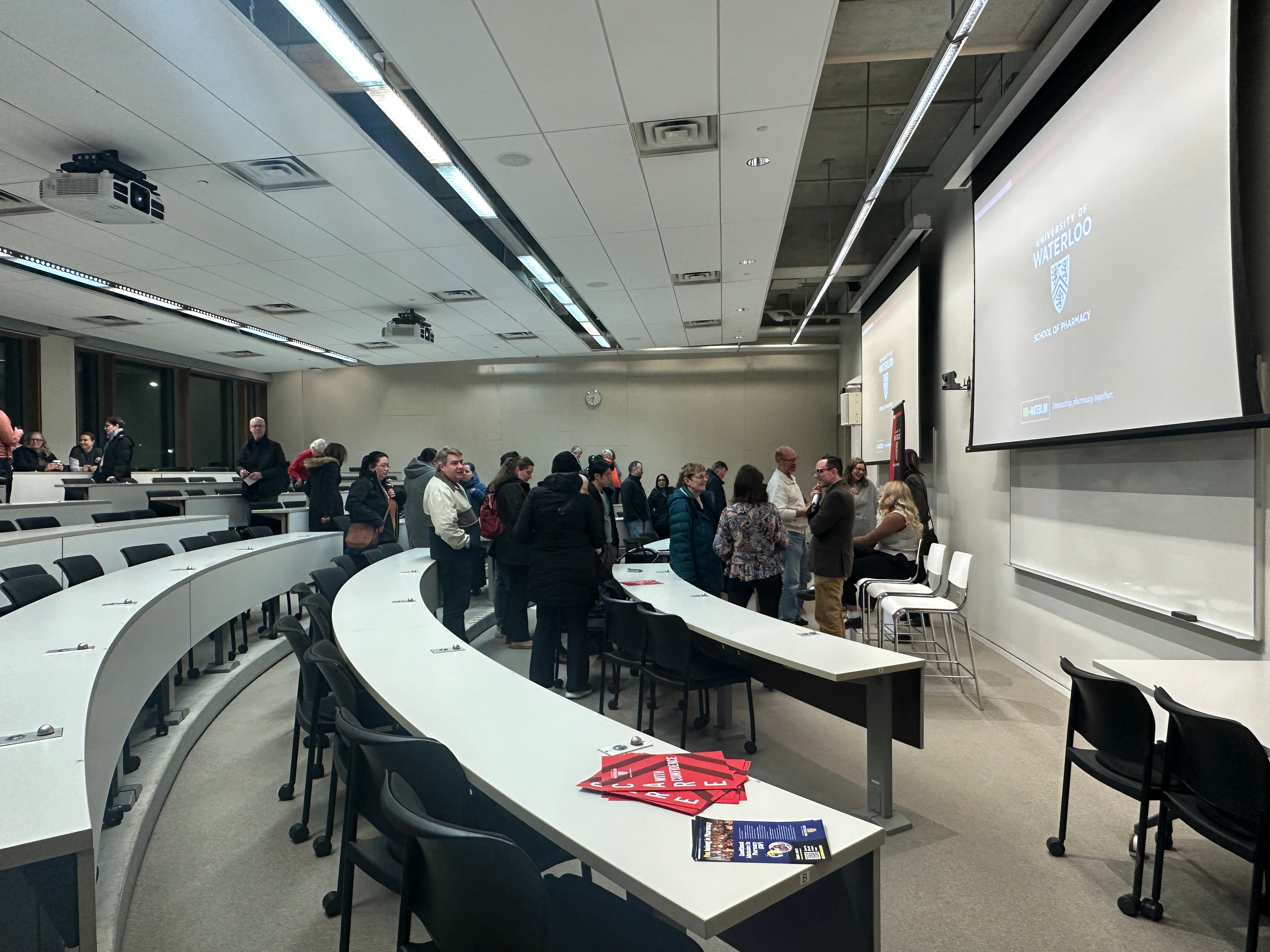 People lining up to ask presenters question in a classroom