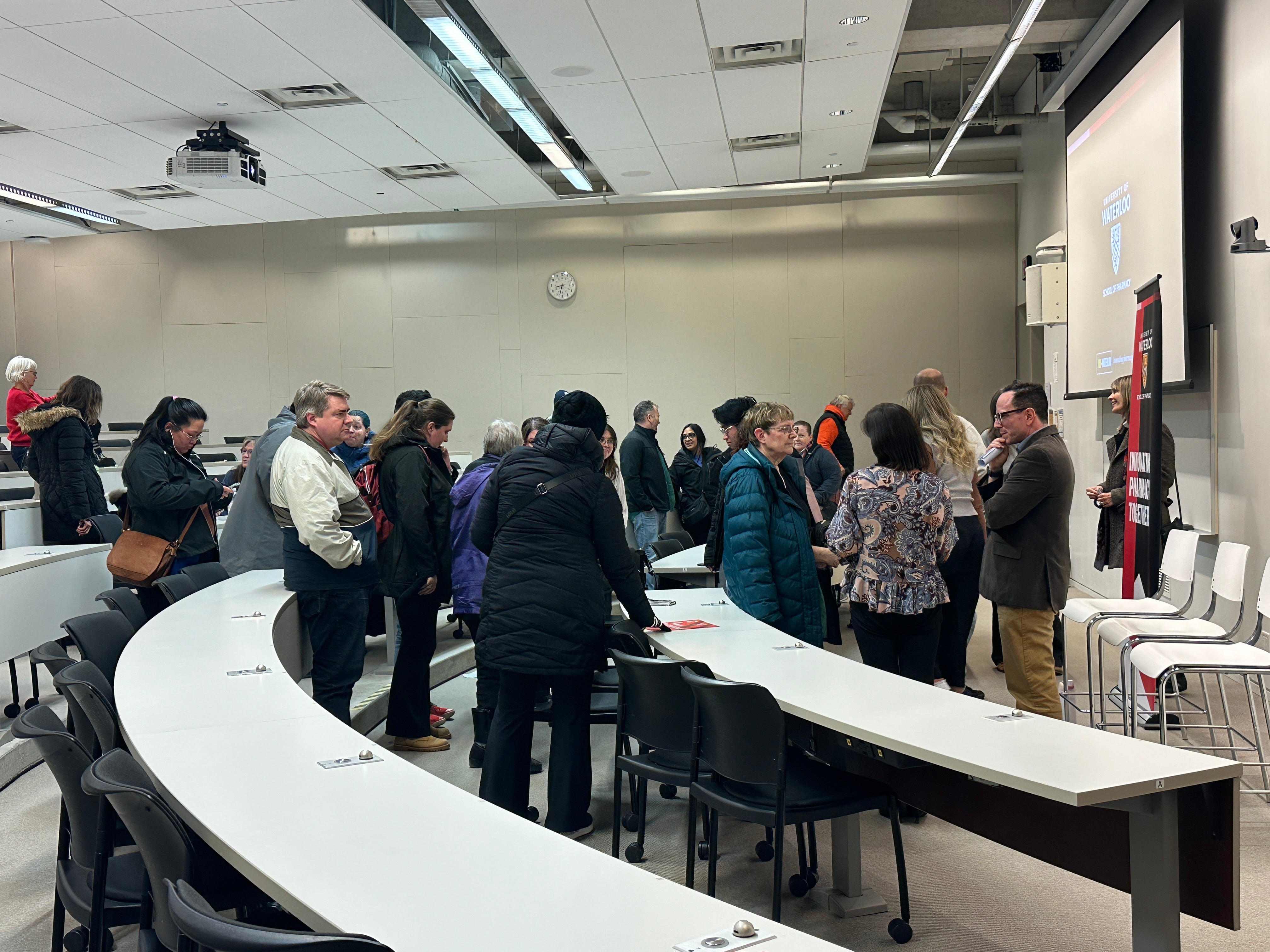 People lining up to ask presenters question in a classroom