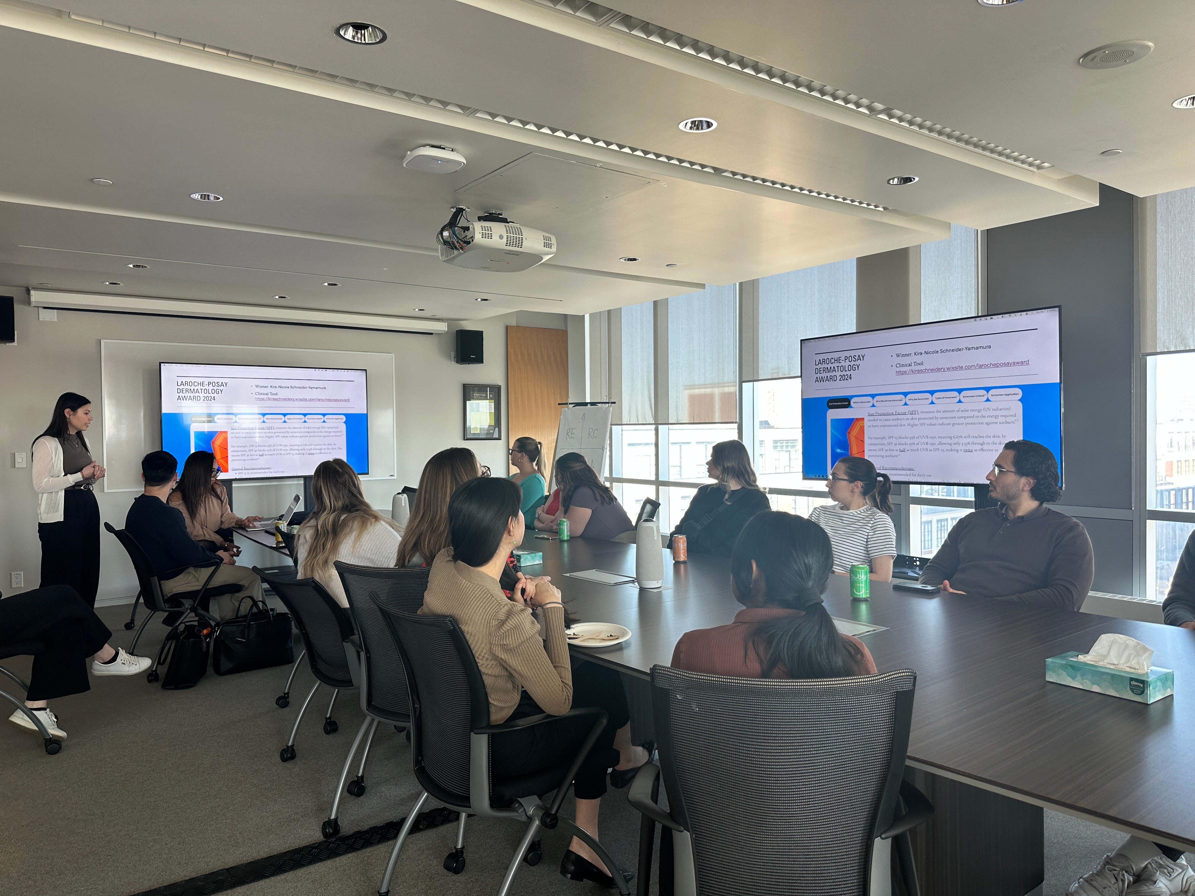 People sitting in a boardroom looking at a large screen
