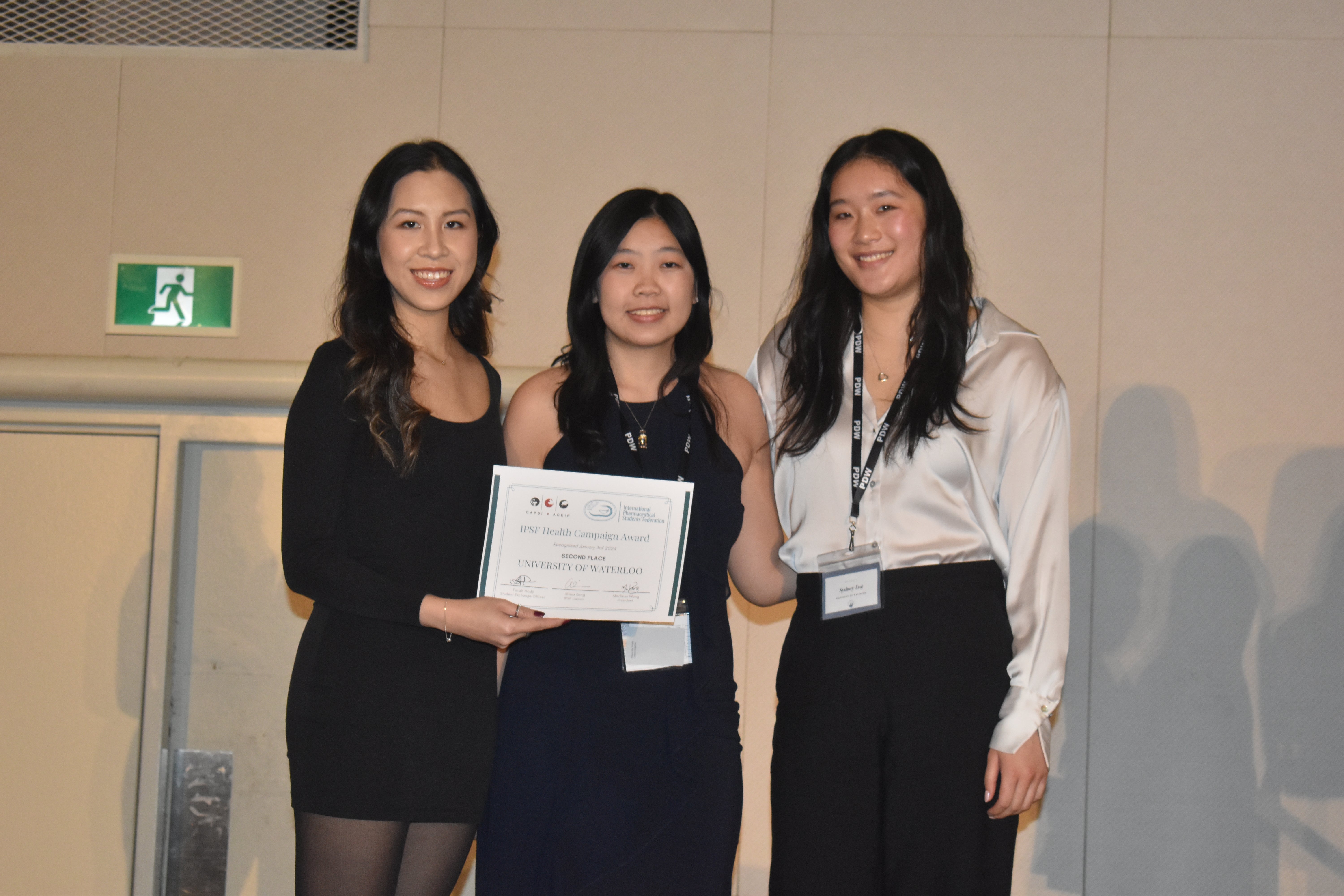 3 women in semi formal wear holding certificates