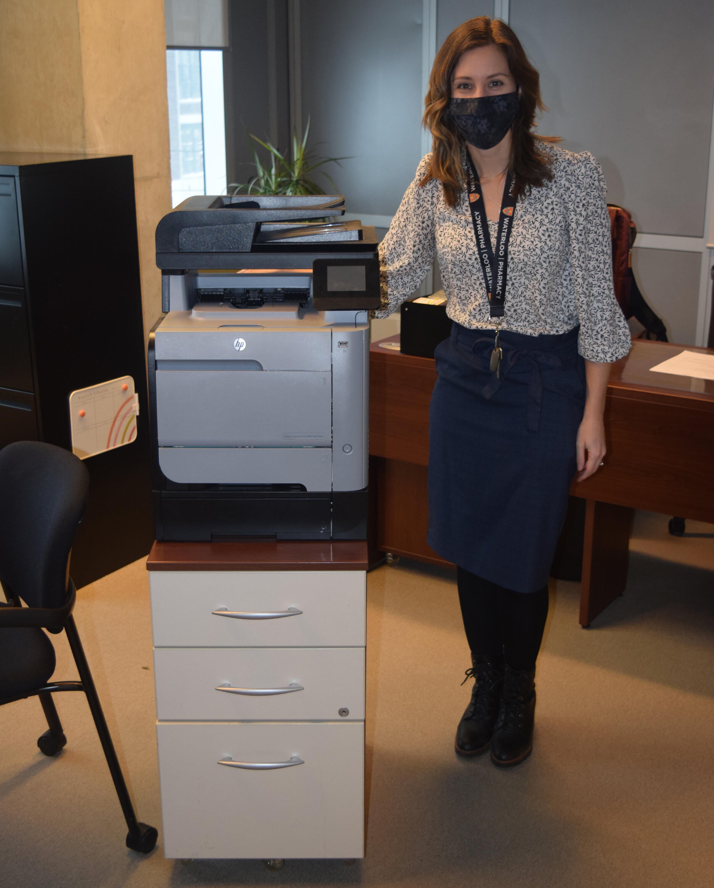 Kiaitlin Bykoski wearing a mask next to her printer
