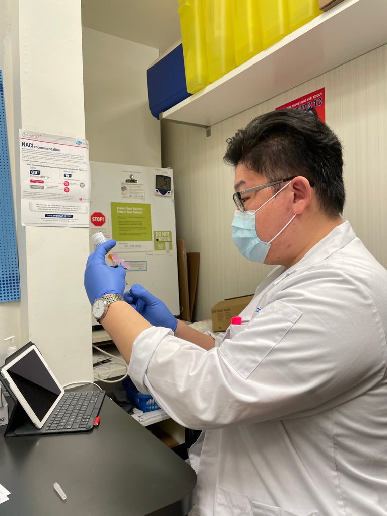 Louis Wei preparing a COVID-19 vaccine