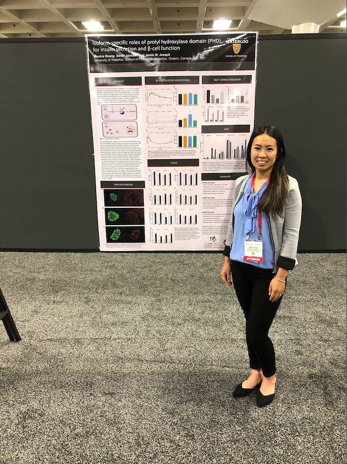 Monica standing next to a poster showcasing her research