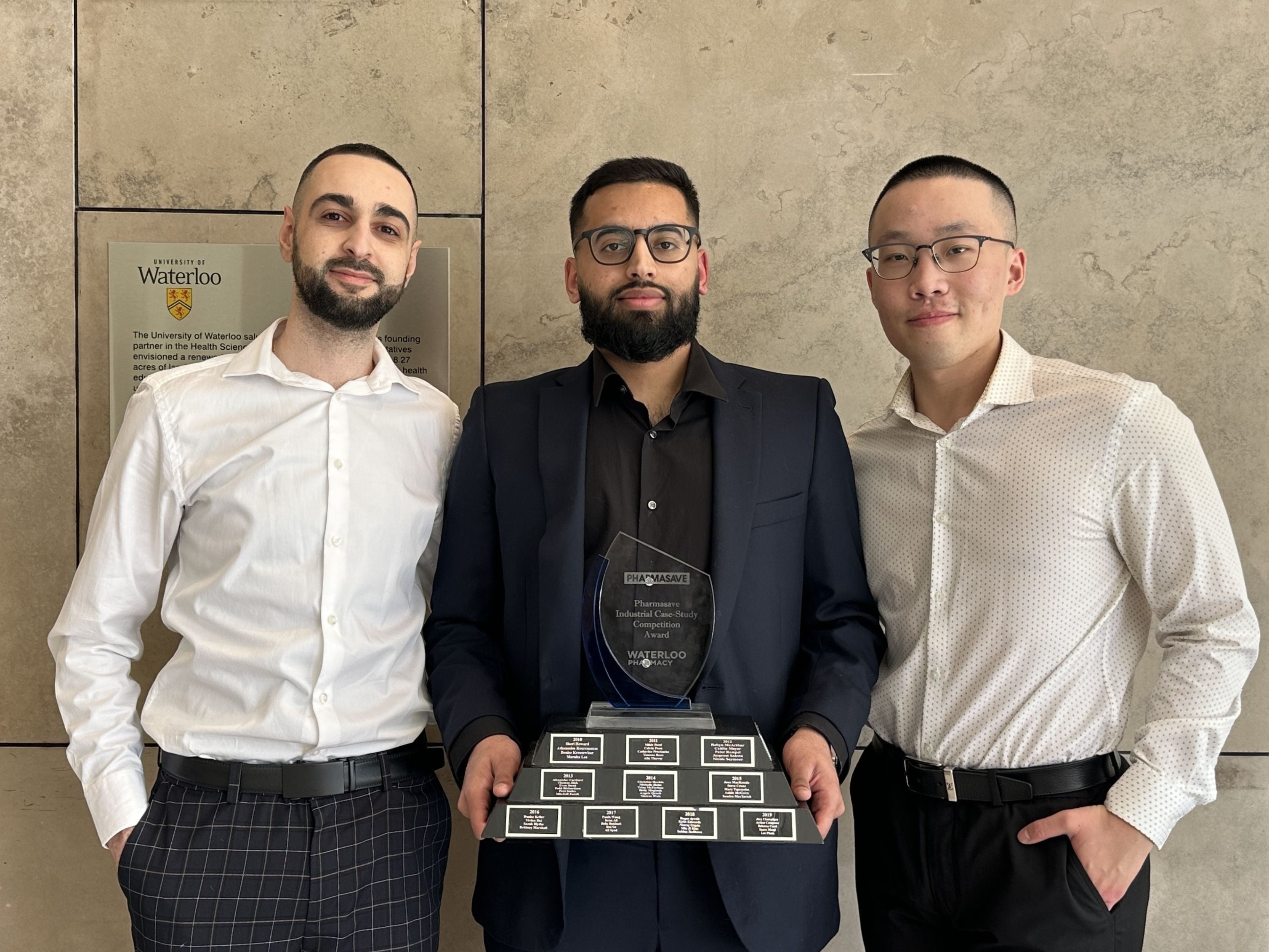 Three students holding an award