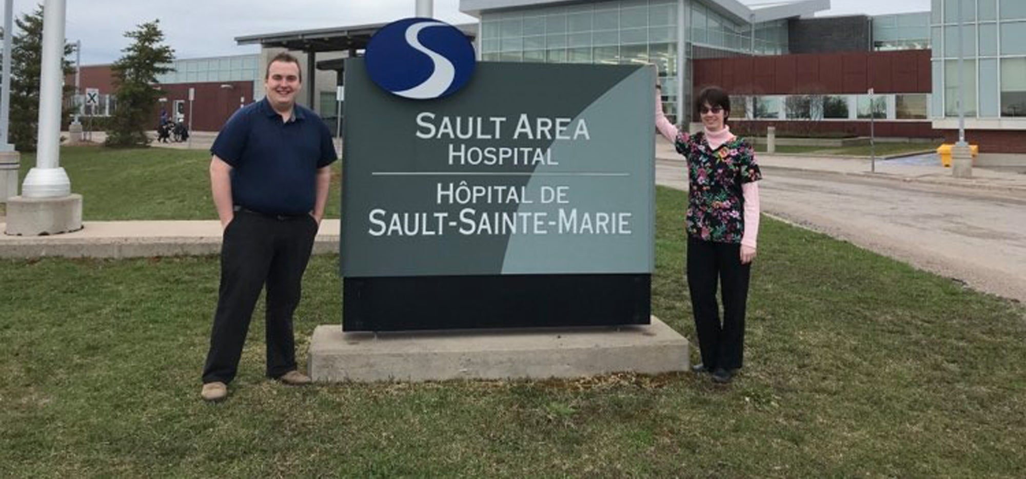 Nick and Krista standing next to a sign that says Sault Area Hospital