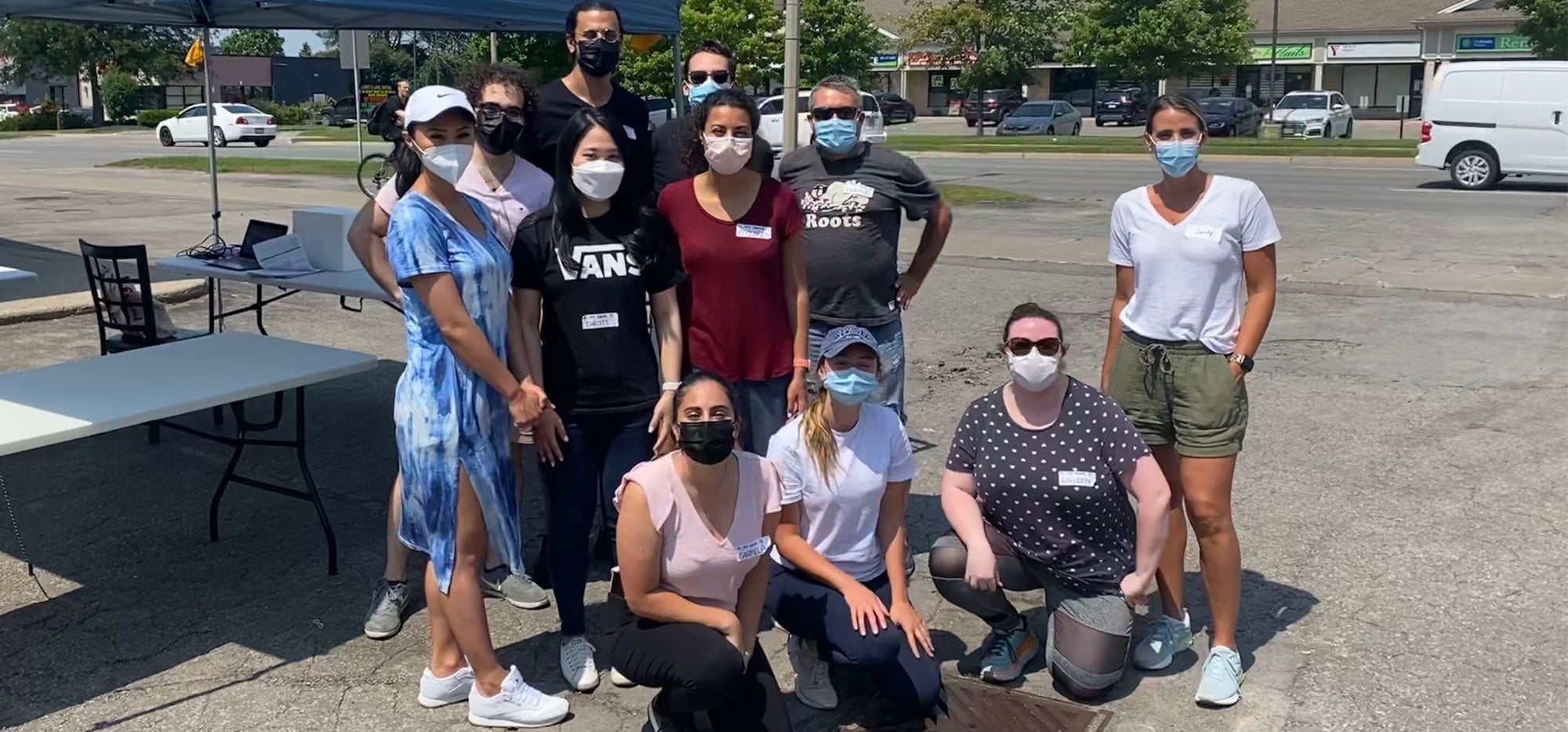 The team that ran the clinic smiling and wearing masks in a parking lot