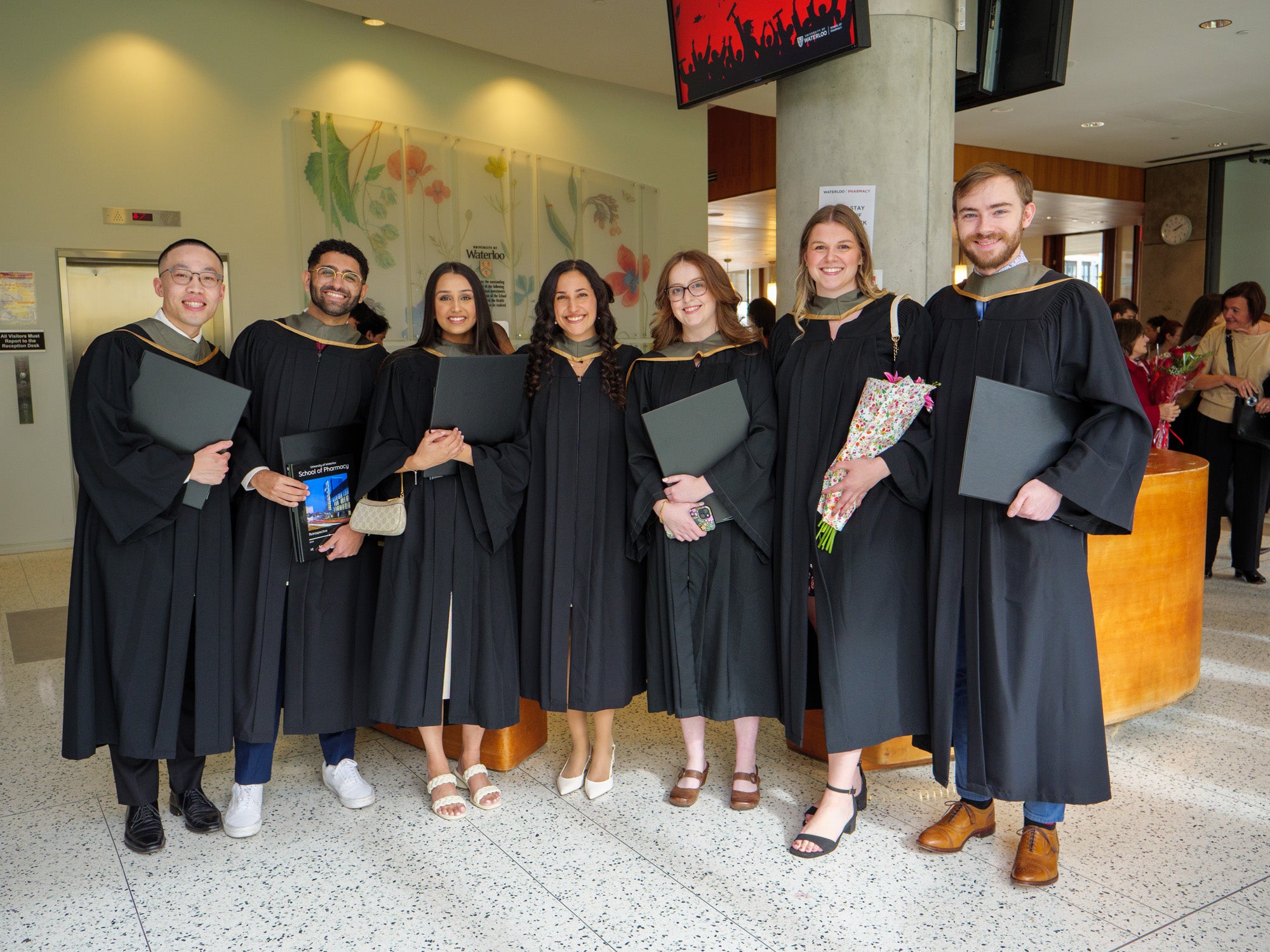 A group of students smiling in their graduation robes