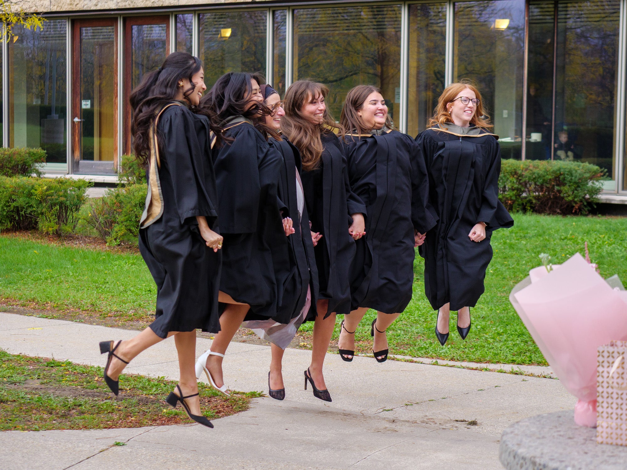 A group of students jumping in their convocation robes