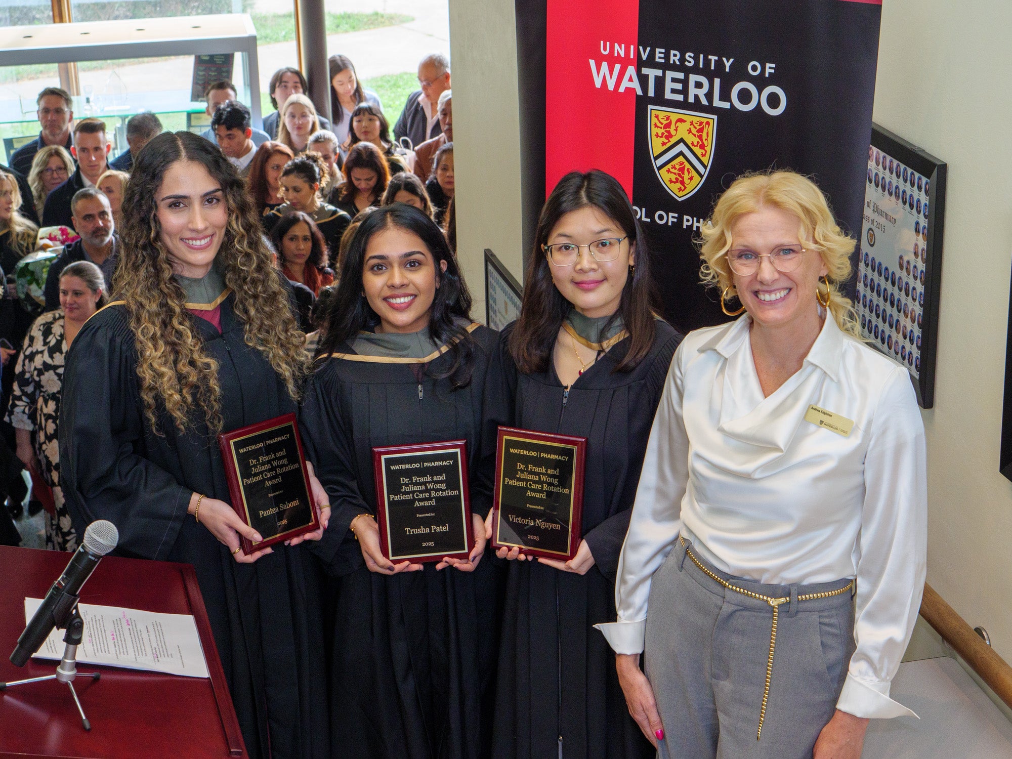 Students holding awards next to the director