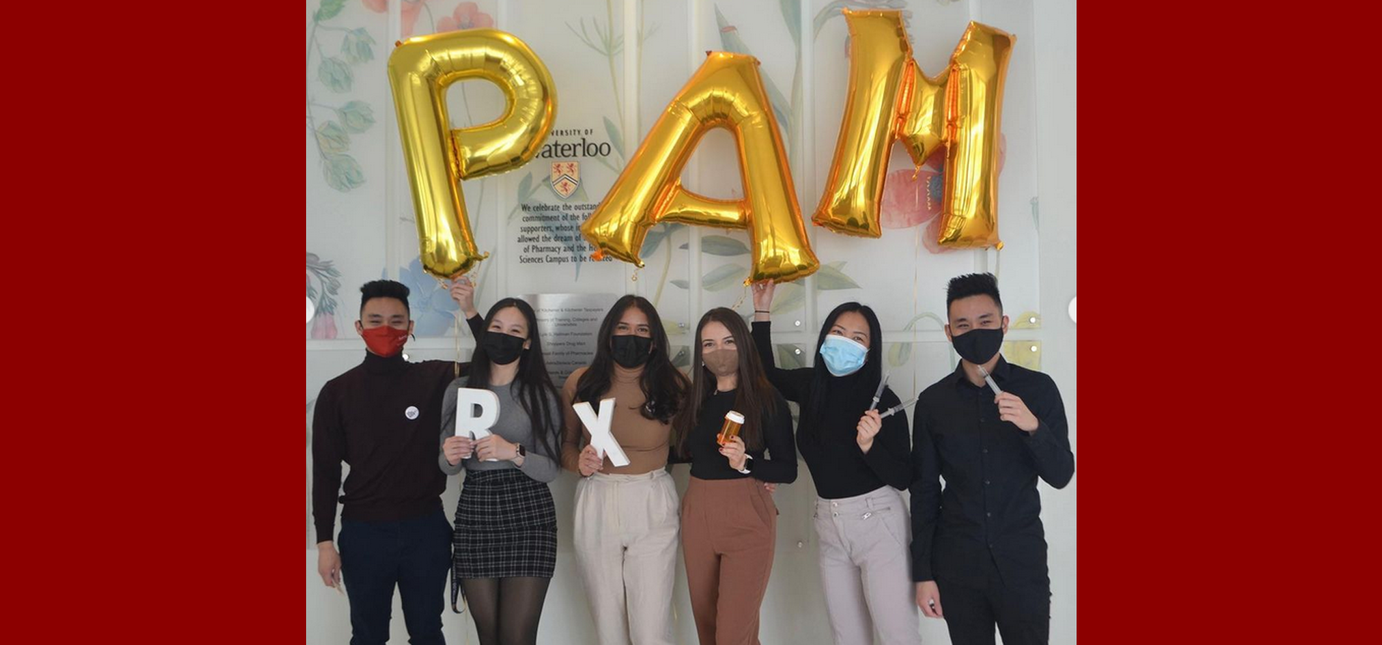 Students standing under PAM ballons wearing masks