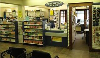Inside Preston Medical Pharmacy. Medicaiton on shelves under 'prescription pick up' sign.
