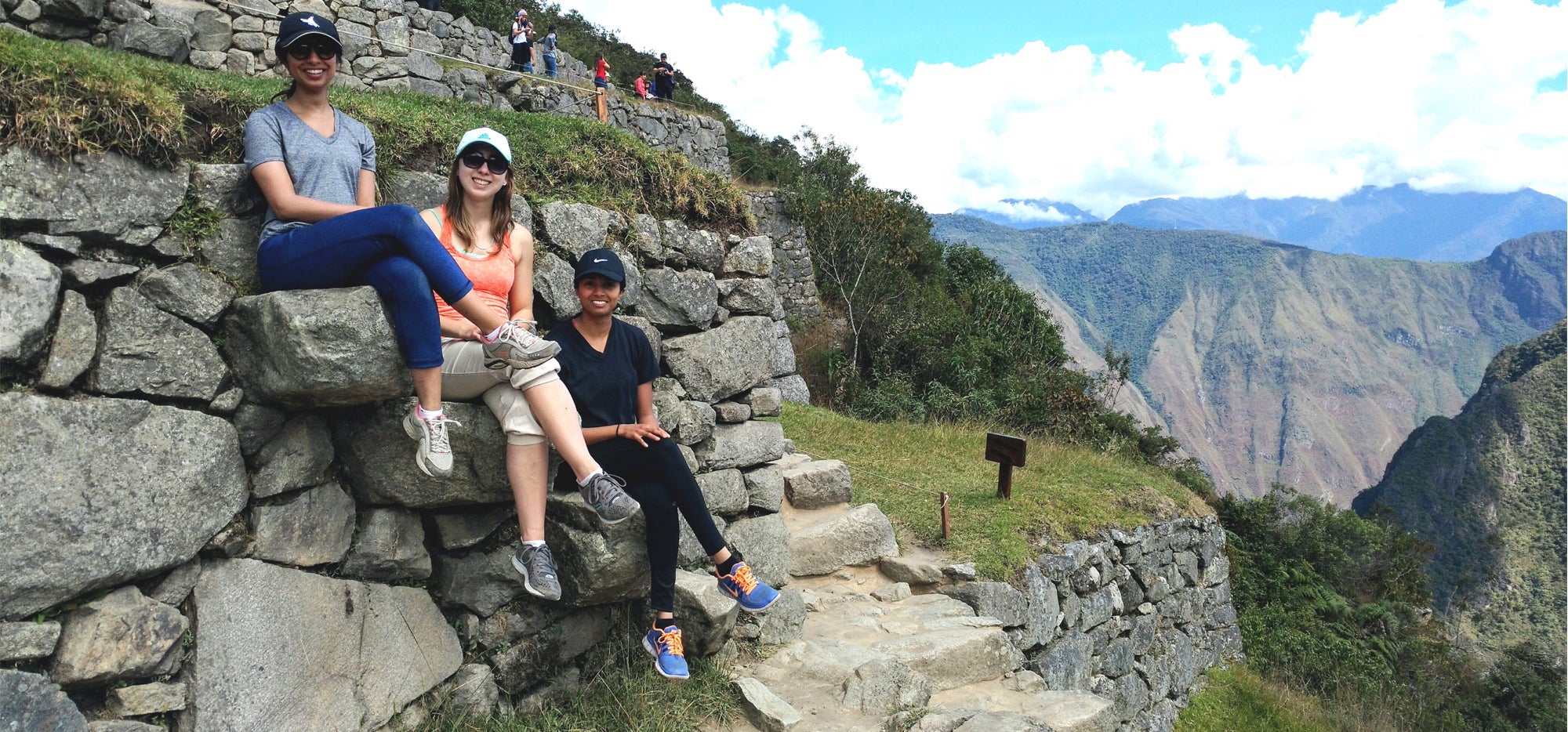 Three students on a wall outside Macchu Picchu