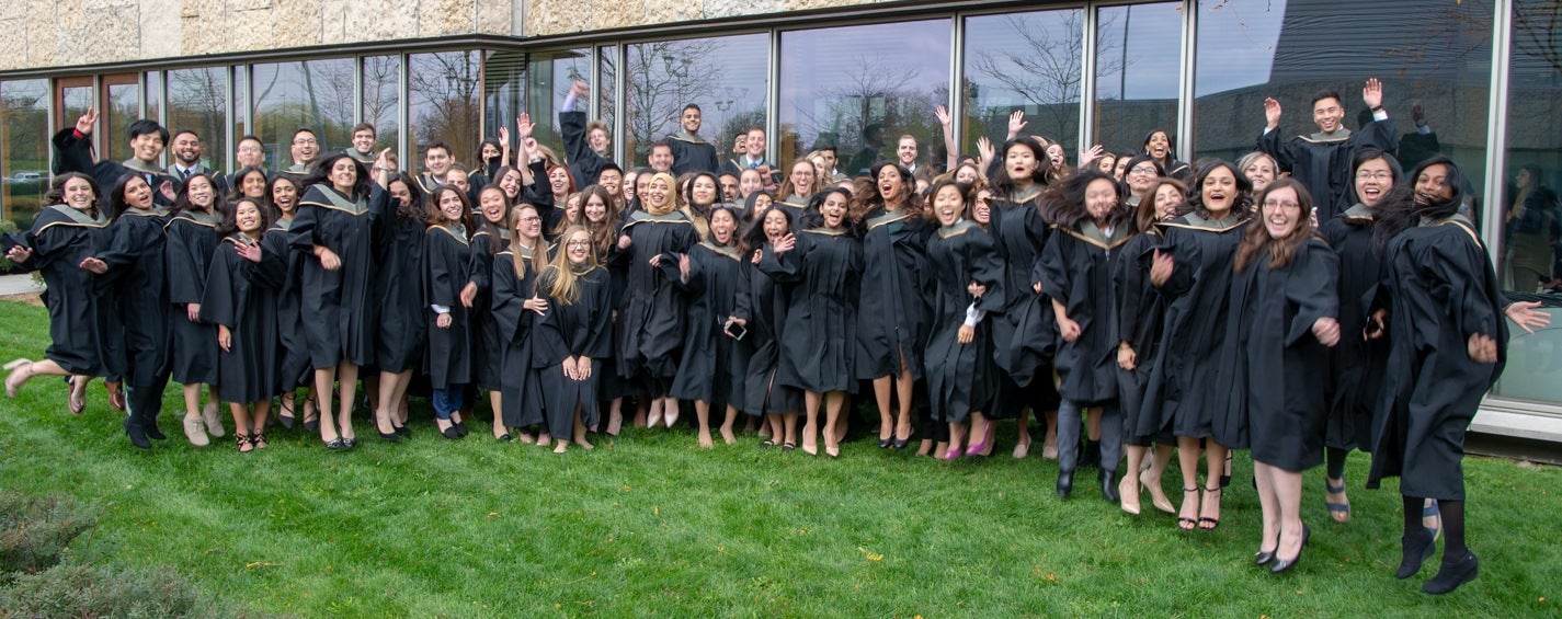 Class of Rx2018 in graduation gowns jumping