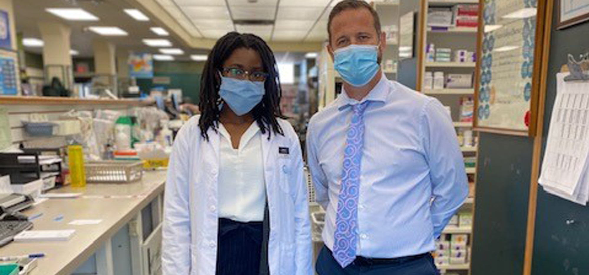 Carolyn Lawrence and Steven Bond wearing masks in the pharmacy