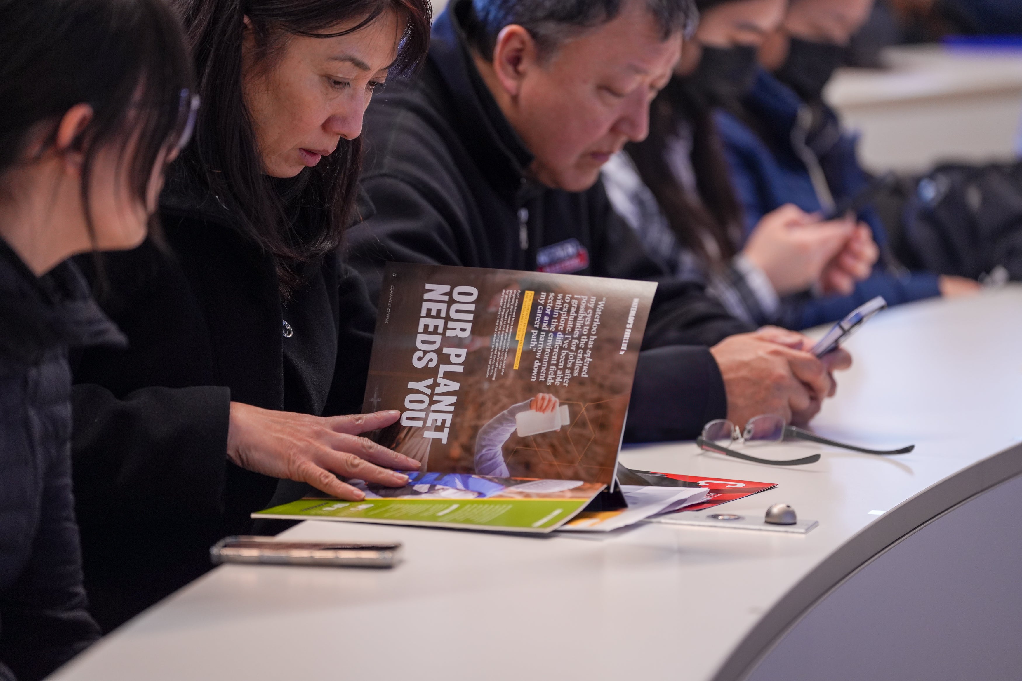 Prospective student and parents reading brochure