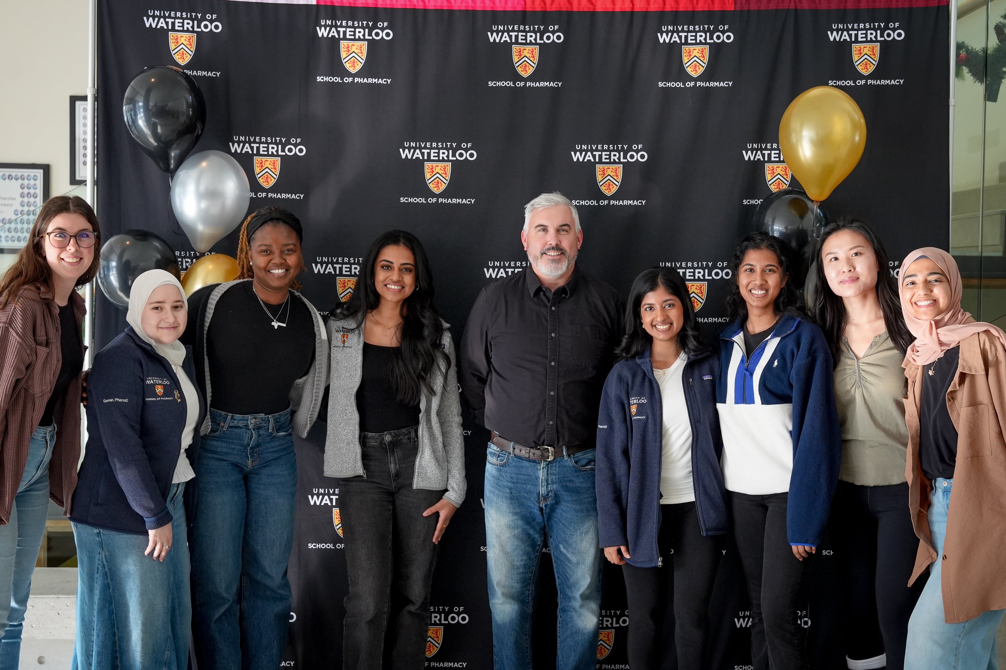 A group of students smiling with a professor