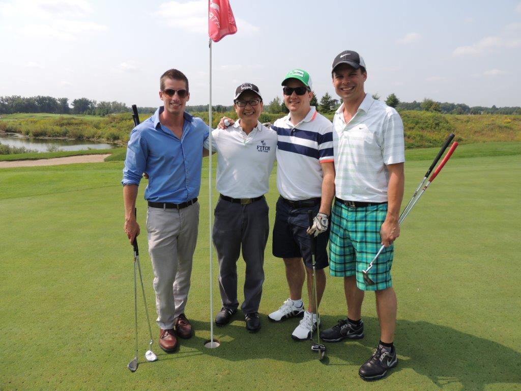 Four alumni on golf course.