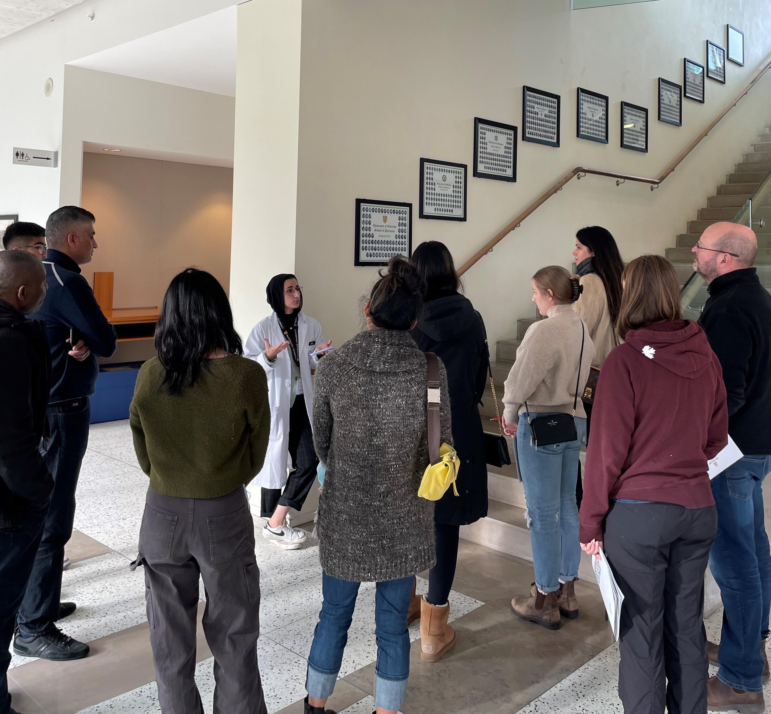 Nasab El-Dassouki (Rx2025) leading a group of prospective students (and parents) on a tour of the Waterloo Pharmacy building.