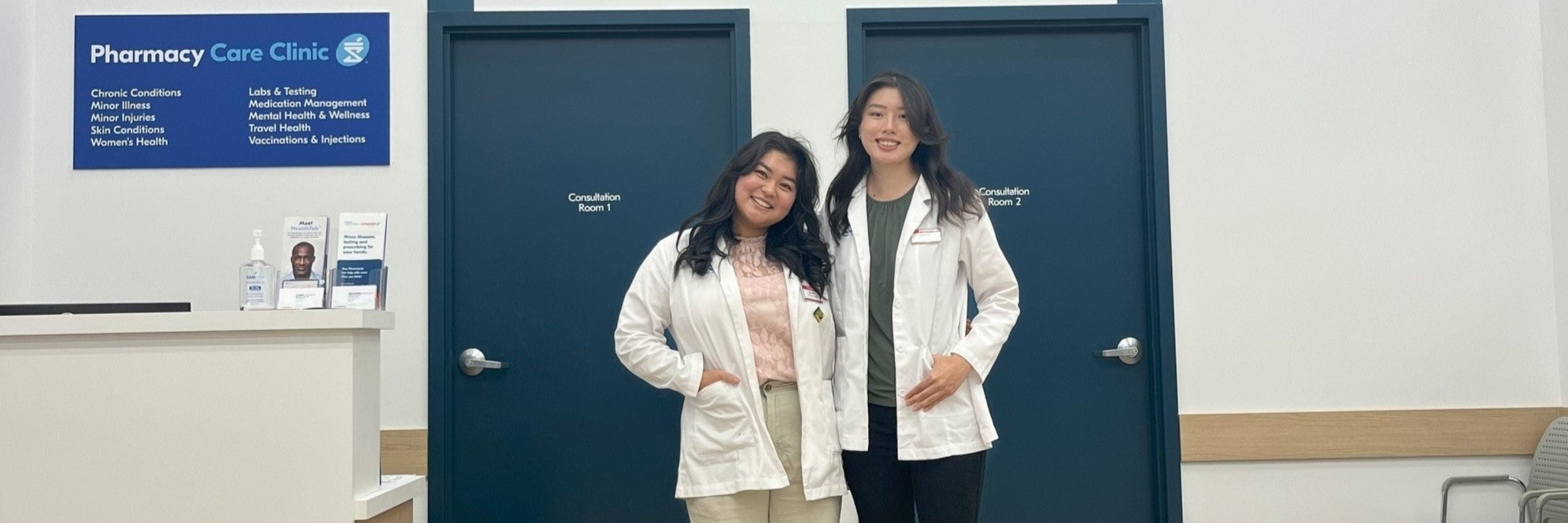 Two students smiling at a pharmacy clinic