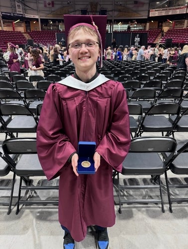 Luca Roy holding a medal at his highschool convocation