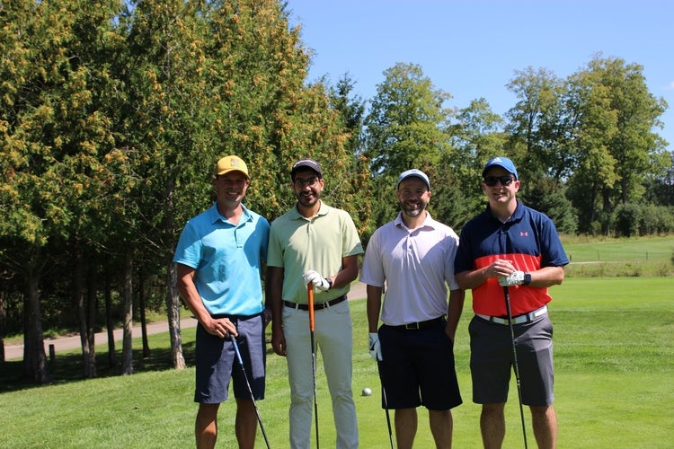 Group of men holding golf clubs