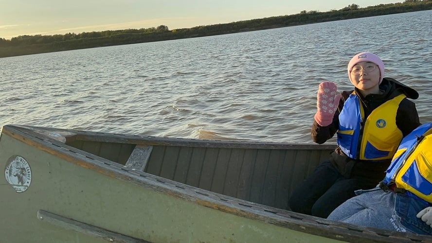 Kelsey Mar waving in a boat