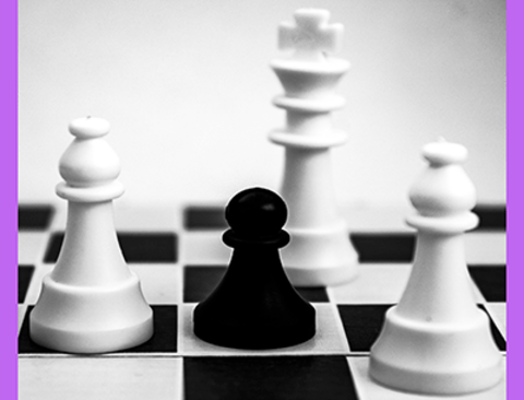 black pawn on a chess board surrounded by white king and bishops