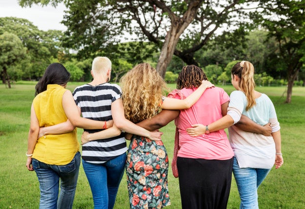 Group of five people with arms around each other