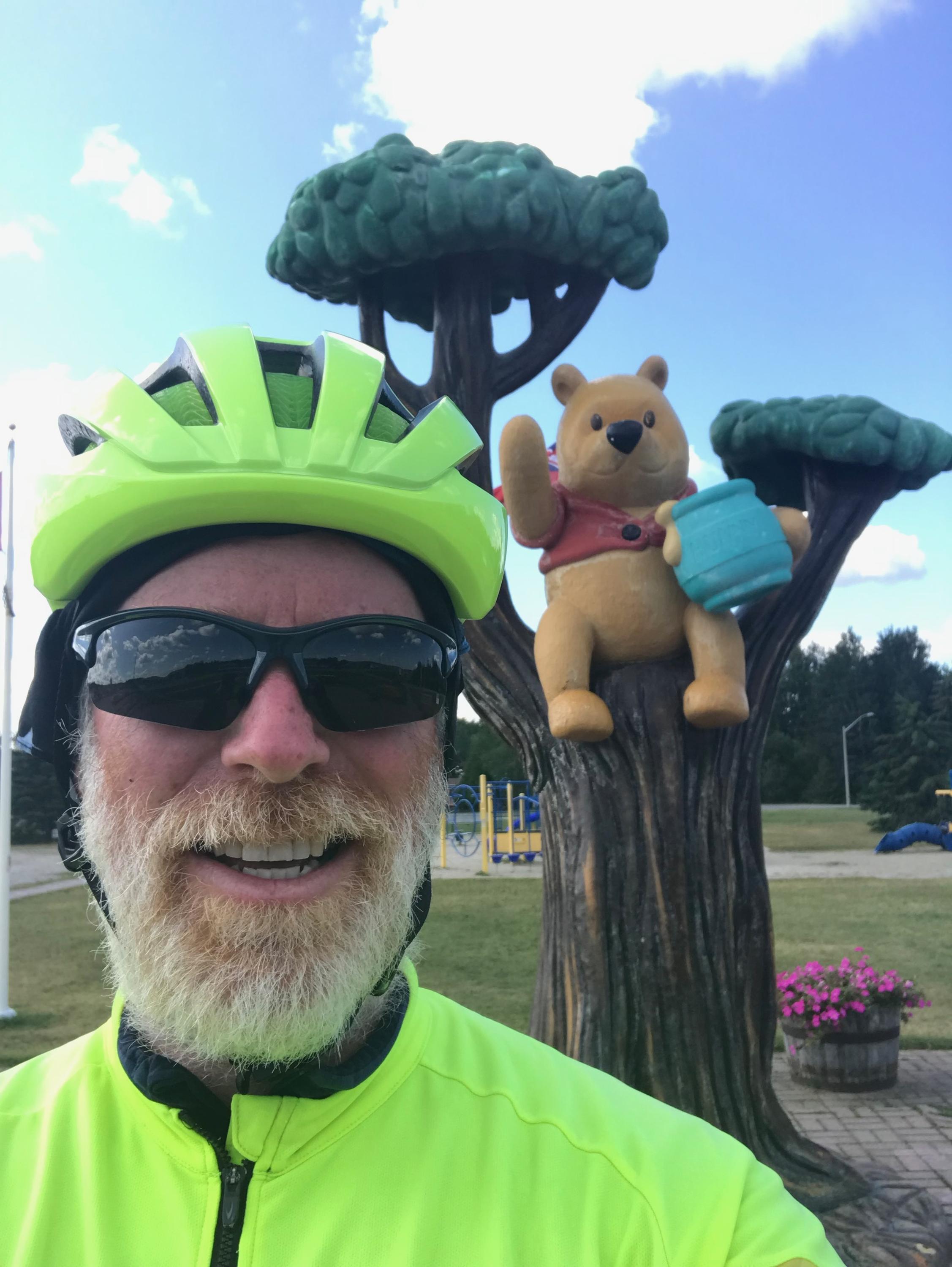 Greg Andres in front of Winnie the Pooh statue