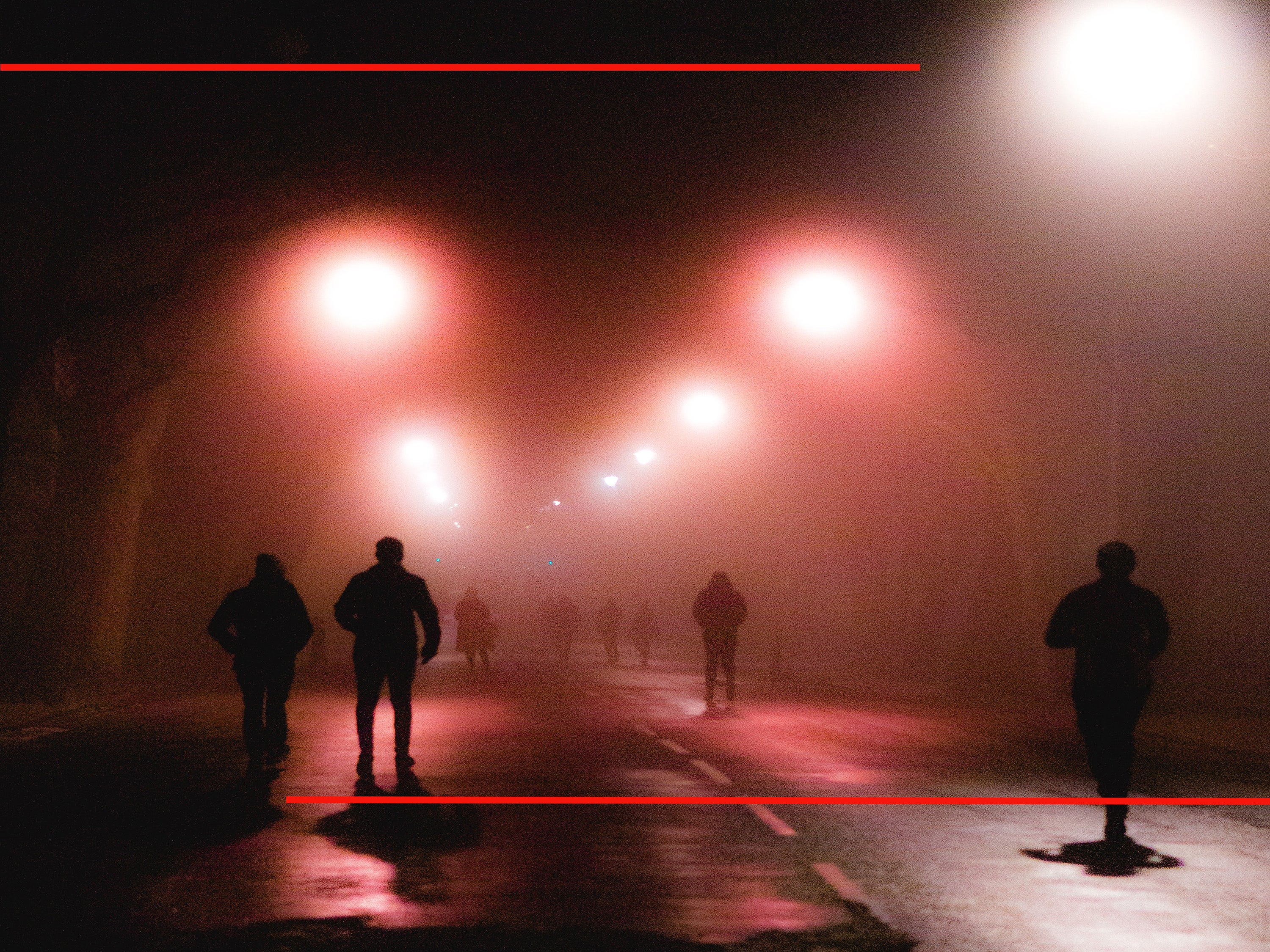 people walking down a dark street at night
