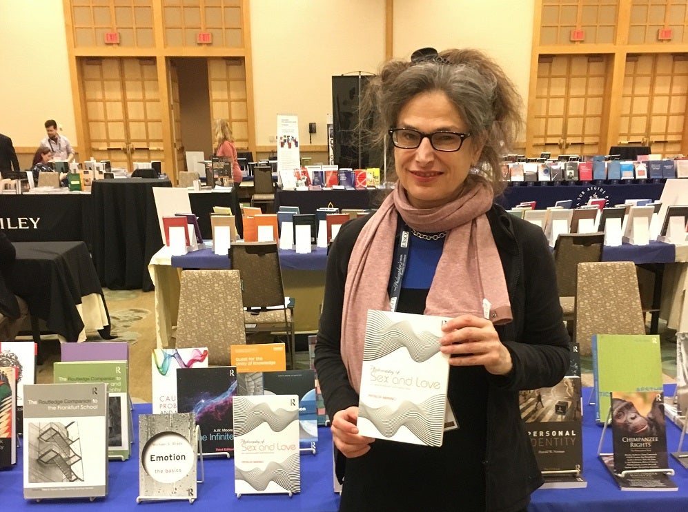 Dr. Patricia Marino, holding a copy of her recent book, Philosophy of Sex and Love