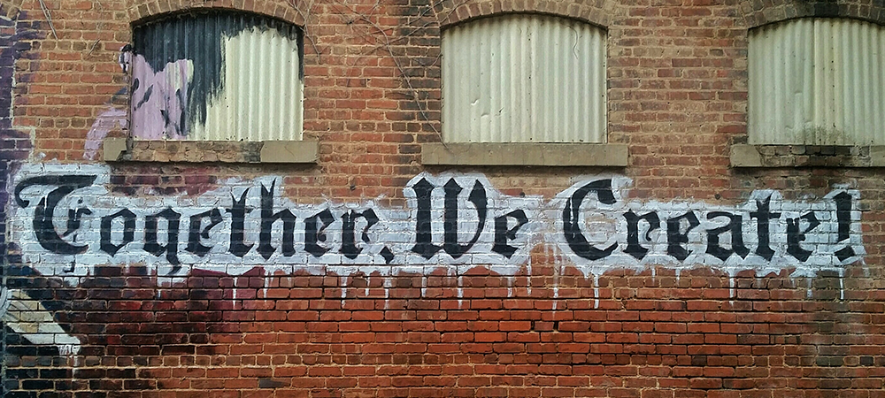 text painted on wal- "Together we create"