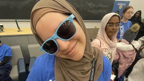 Young female student smiles playfully at the camera.