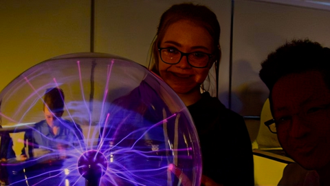 Students playing with a plasma globe.