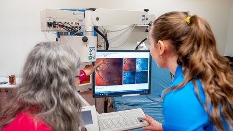 Melanie Campbell and a researcher examine a computer image for signs of protein TDP-43 deposits.