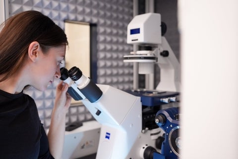 Student looking through a microscope.