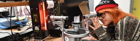 Student looking through view port of a laser device.