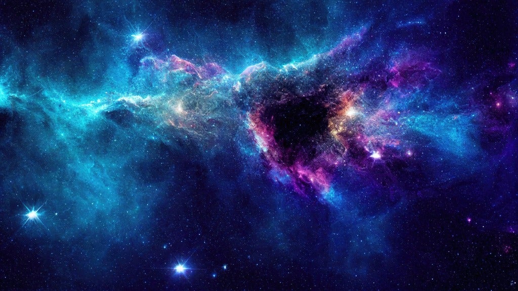 A colorful nebula with blue, purple, and pink clouds of gas and stars scattered across a dark space background.