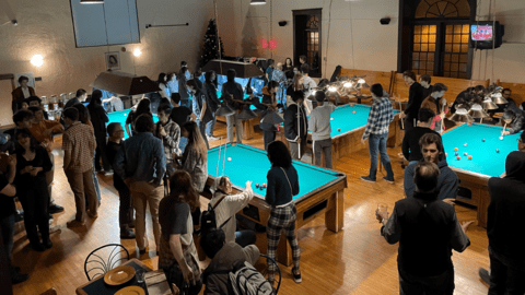 Physics students and faculty playing pool.
