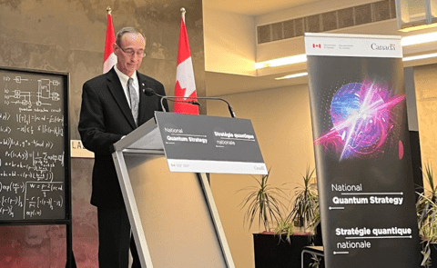 Dr. Ray Laflamme standing behind a National Quantum Strategy podium