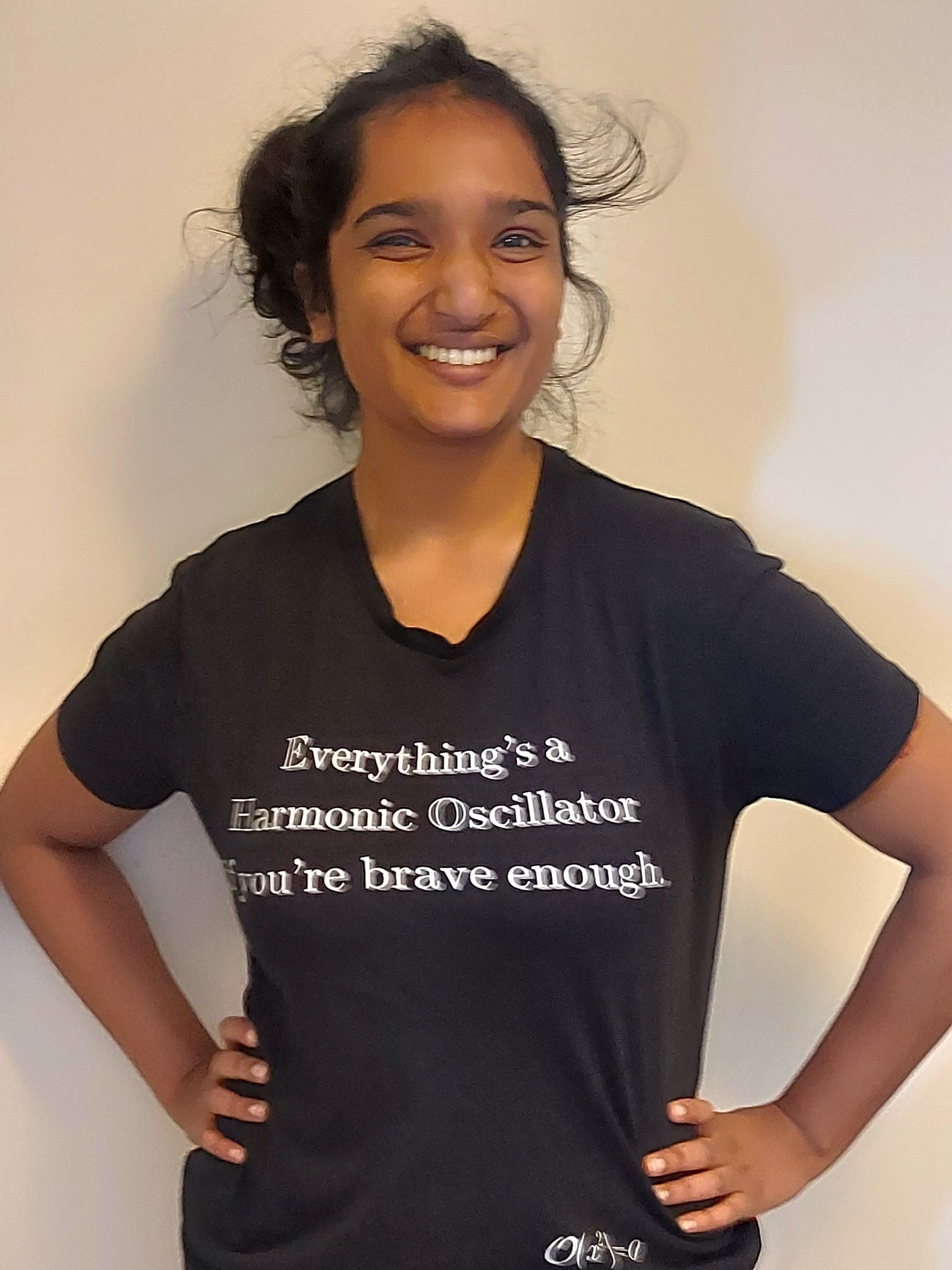 Urja wearing a T-shirt with the words "Everything is a Harmonic Oscillator if you're brave enough."