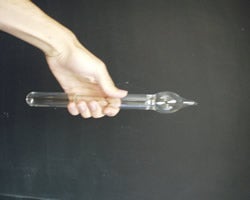 Photograph of a hand holding the glass water hammer
