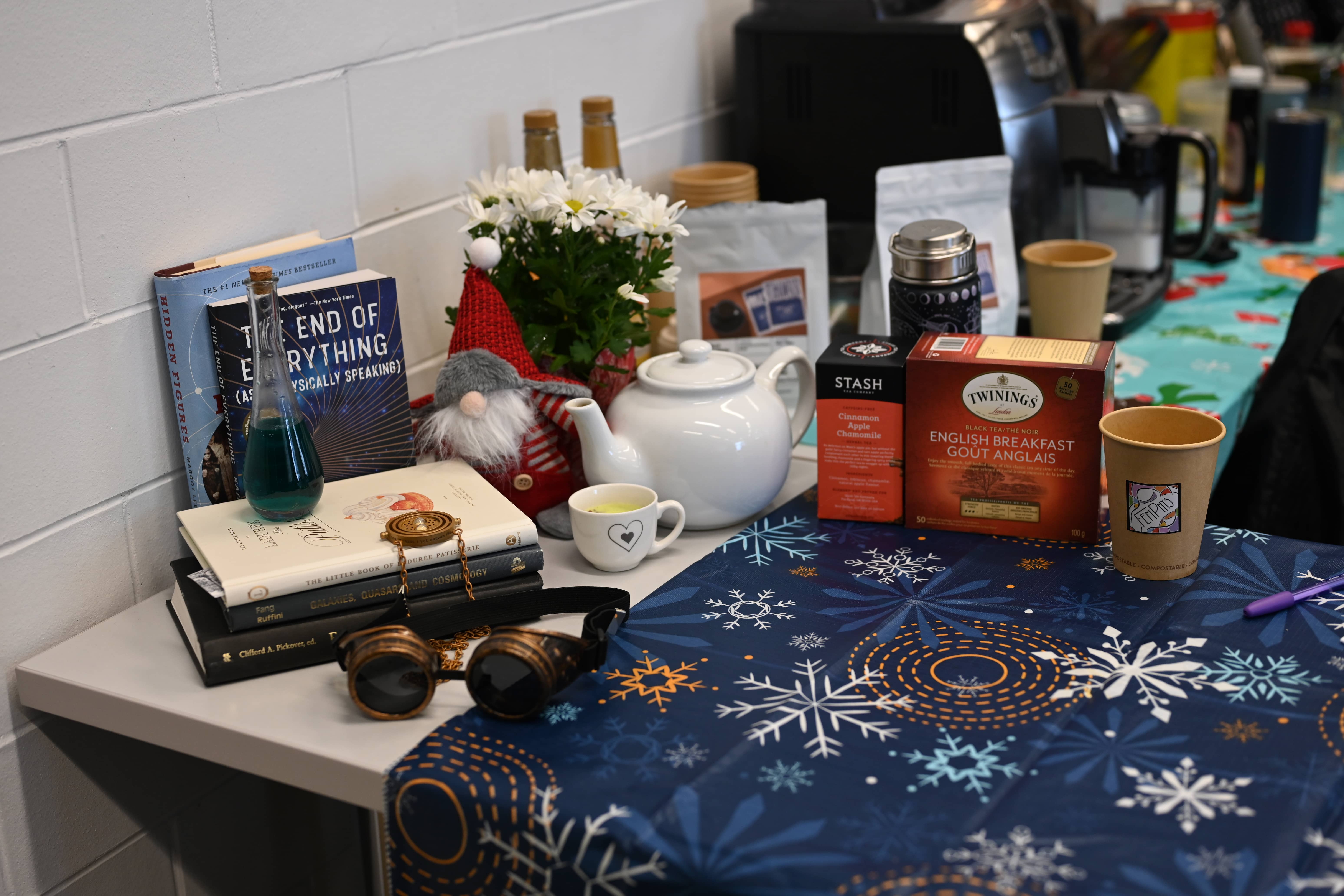 Tea and coffee with astrophysics books on a table.
