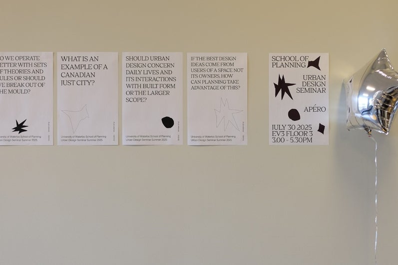 Papers with questions on them taped to a wall near a balloon